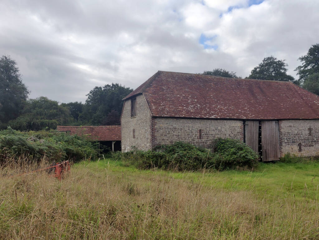 A recently derelict barn with pried open door.