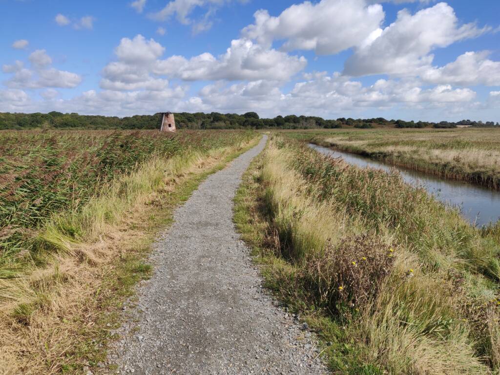 coastal trail running views over grassland and canal.