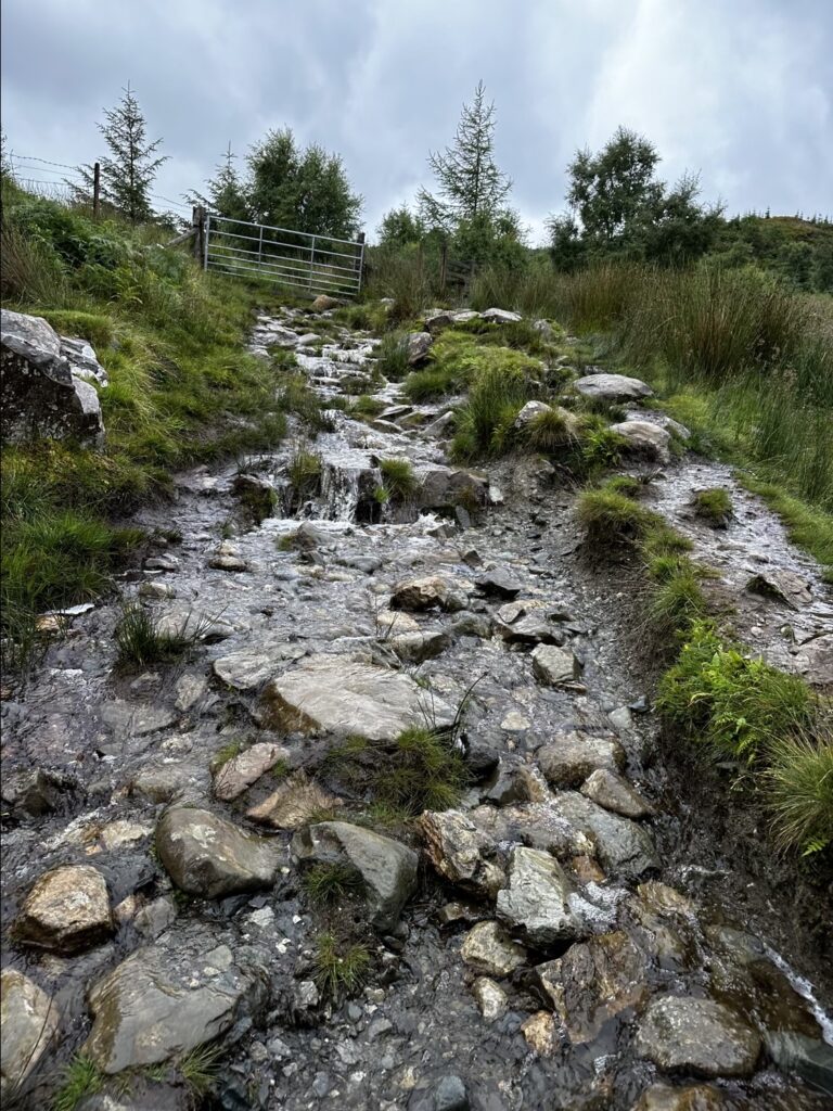 river flowing down rocky trail on the Capel Curig leg of the Paddy Buckley Round up toward Moel Siabod.